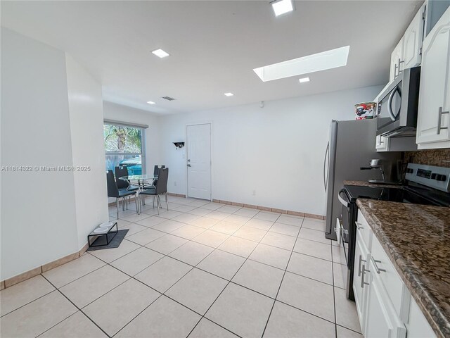 14751 SW 158th St, Miami, FL 33187 - kitchen featuring stainless steel appliances, a skylight, white cabinetry, dark stone countertops, and recessed lighting