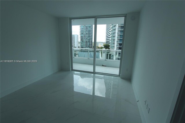 1080 Brickell Ave Unit 1409, Miami, FL 33131 - unfurnished room with marble finish flooring, baseboards, expansive windows, and a view of city