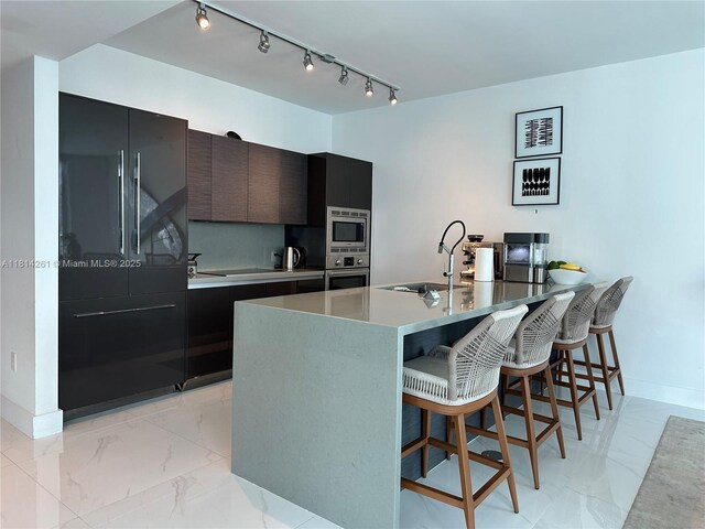 1080 Brickell Ave Unit 1409, Miami, FL 33131 - kitchen with stainless steel appliances, a sink, modern cabinets, light marble finish floors, and a kitchen breakfast bar