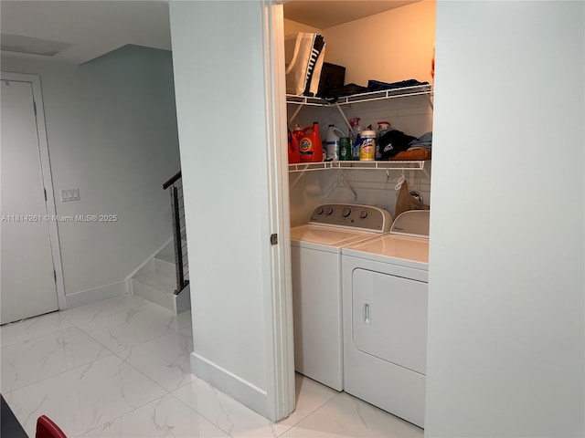 1080 Brickell Ave Unit 1409, Miami, FL 33131 - laundry area featuring washing machine and dryer, marble look tiles, and baseboards