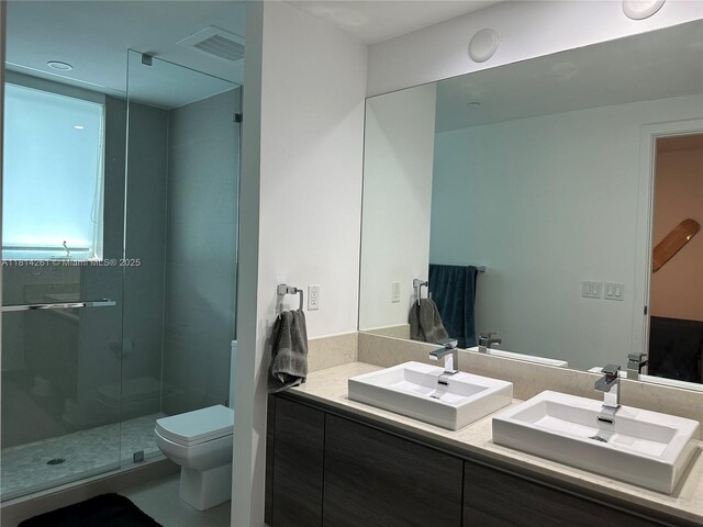 1080 Brickell Ave Unit 1409, Miami, FL 33131 - bathroom featuring double vanity, toilet, and a shower stall