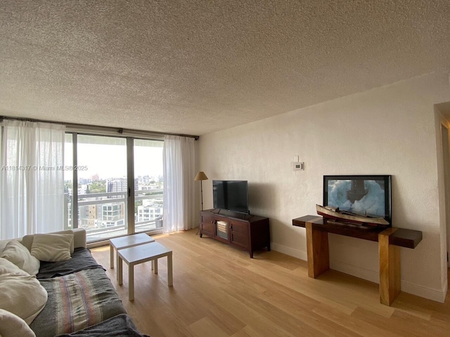1500 Bay Rd Unit 1274S, Miami Beach, FL 33139 - living room featuring light wood-style flooring, a textured ceiling, and baseboards