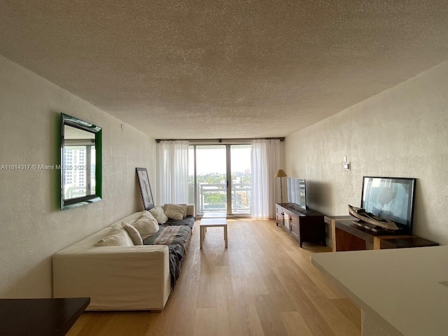 1500 Bay Rd Unit 1274S, Miami Beach, FL 33139 - living room featuring a textured wall, light wood-style floors, a textured ceiling, and expansive windows