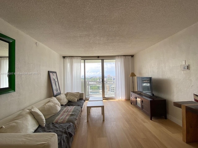 1500 Bay Rd Unit 1274S, Miami Beach, FL 33139 - living area featuring light wood-type flooring, a textured wall, a textured ceiling, and floor to ceiling windows