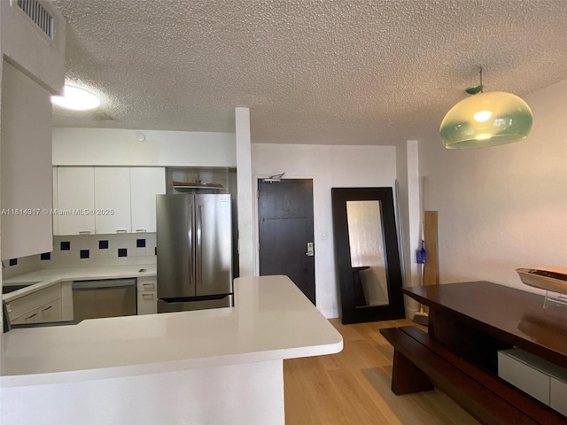 1500 Bay Rd Unit 1274S, Miami Beach, FL 33139 - kitchen featuring appliances with stainless steel finishes, a textured ceiling, light wood-style flooring, light countertops, and white cabinets