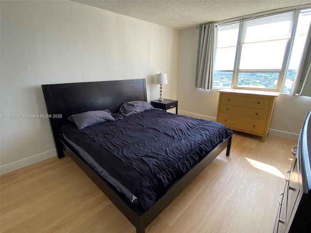 1500 Bay Rd Unit 1274S, Miami Beach, FL 33139 - bedroom featuring light wood-style flooring, a textured ceiling, and baseboards