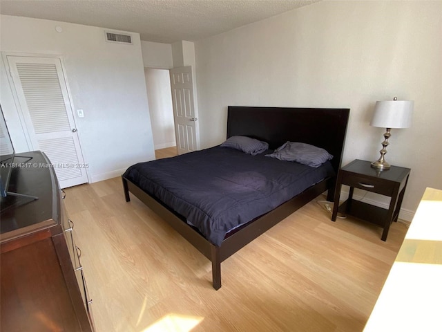 1500 Bay Rd Unit 1274S, Miami Beach, FL 33139 - bedroom featuring light wood-style floors, baseboards, and a textured ceiling