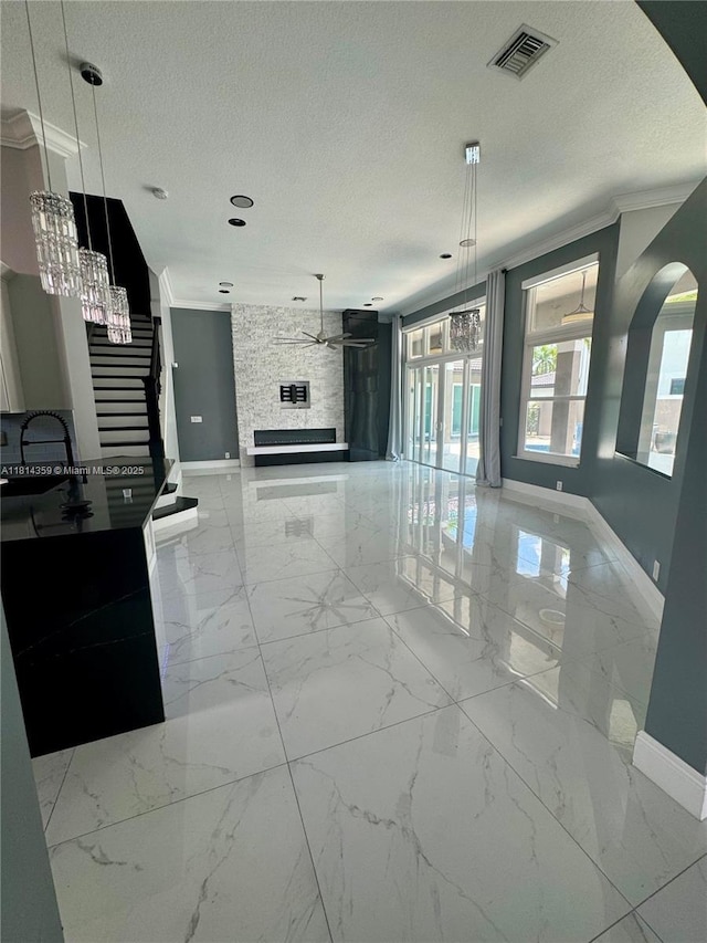 4248 SW 185th Ave, Miramar, FL 33029 - unfurnished living room with baseboards, a ceiling fan, a textured ceiling, crown molding, and arched walkways