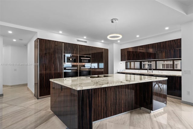18555 Collins Ave Unit 2105, Sunny Isles Beach, FL 33160 - kitchen featuring modern cabinets, a large island, recessed lighting, black electric stovetop, and decorative light fixtures