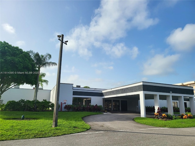 4820 W Lucerne Lakes Blvd W Unit 305, Lake Worth, FL 33467 - view of property with asphalt driveway and a carport