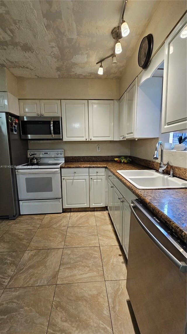 3390 SW 15th Ct, Fort Lauderdale, FL 33312 - kitchen featuring stainless steel appliances, white cabinets, and dark countertops