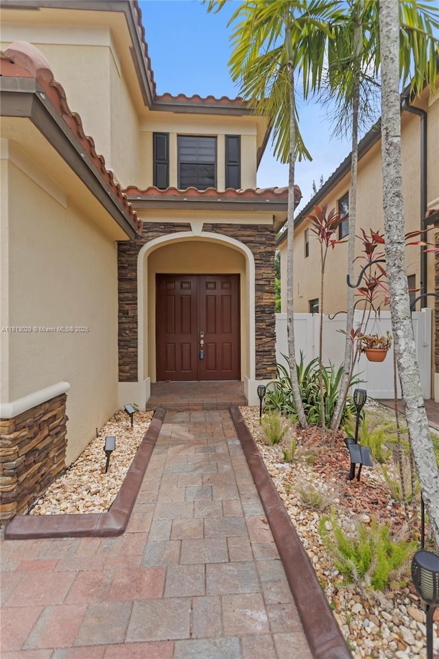 3502 W 86th Ter, Hialeah, FL 33018 - doorway to property featuring stucco siding, a tile roof, and stone siding