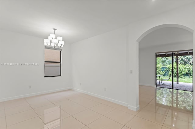 3502 W 86th Ter, Hialeah, FL 33018 - unfurnished room with arched walkways, light tile patterned floors, a chandelier, and baseboards