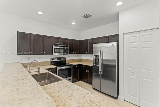 3502 W 86th Ter, Hialeah, FL 33018 - kitchen with stainless steel appliances, a sink, light tile patterned flooring, light countertops, and dark brown cabinetry