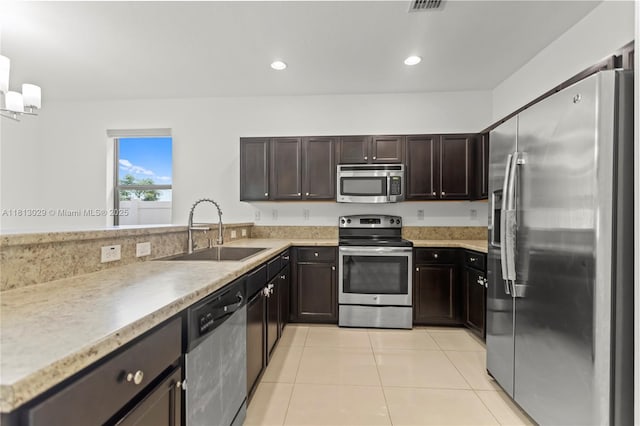 3502 W 86th Ter, Hialeah, FL 33018 - kitchen with stainless steel appliances, a sink, light tile patterned flooring, light countertops, and dark brown cabinets