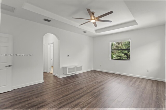 3502 W 86th Ter, Hialeah, FL 33018 - spare room featuring a raised ceiling, dark wood finished floors, a ceiling fan, arched walkways, and baseboards