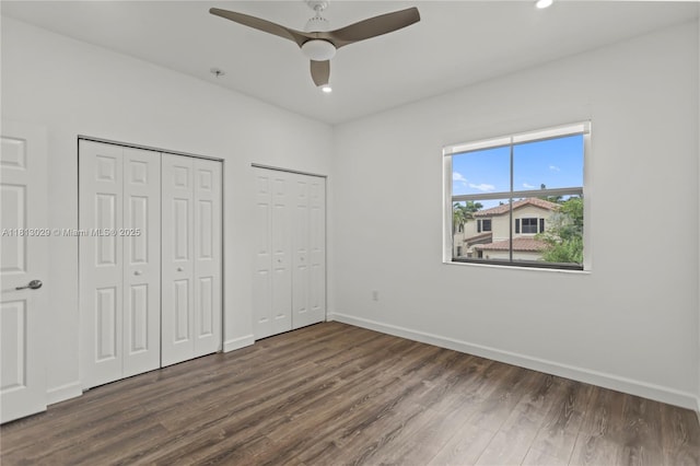 3502 W 86th Ter, Hialeah, FL 33018 - unfurnished bedroom featuring two closets, dark wood-style flooring, baseboards, a ceiling fan, and recessed lighting