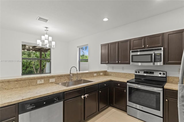 3502 W 86th Ter, Hialeah, FL 33018 - kitchen with stainless steel appliances, a sink, a chandelier, dark brown cabinetry, and pendant lighting