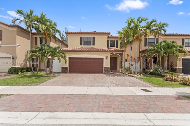 3502 W 86th Ter, Hialeah, FL 33018 - mediterranean / spanish house featuring stucco siding, decorative driveway, a tile roof, and stone siding