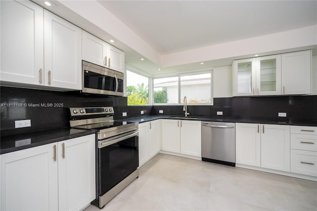 6640 SW 7th St, Pembroke Pines, FL 33023 - kitchen with appliances with stainless steel finishes, decorative backsplash, dark countertops, white cabinets, and recessed lighting