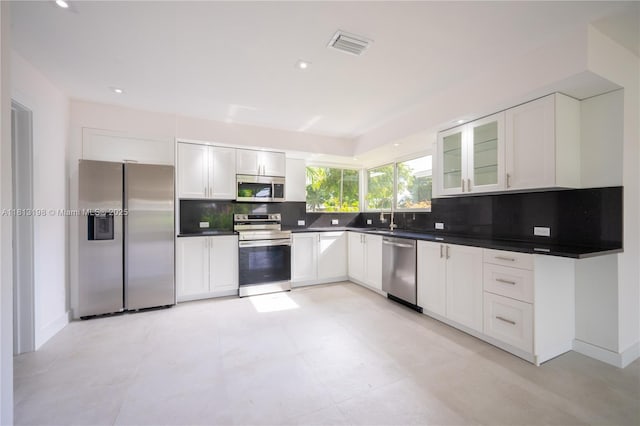 6640 SW 7th St, Pembroke Pines, FL 33023 - kitchen featuring stainless steel appliances, decorative backsplash, white cabinets, dark countertops, and recessed lighting