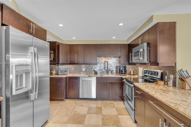 875 E Camino Real Unit 5D, Boca Raton, FL 33432 - kitchen with stainless steel appliances, a sink, light stone countertops, decorative backsplash, and recessed lighting