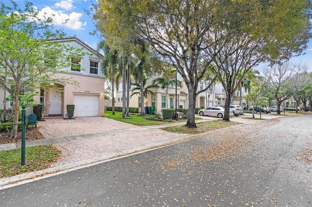 16316 SW 48th St, Miramar, FL 33027 - townhome / multi-family property featuring an attached garage, stucco siding, decorative driveway, and a residential view
