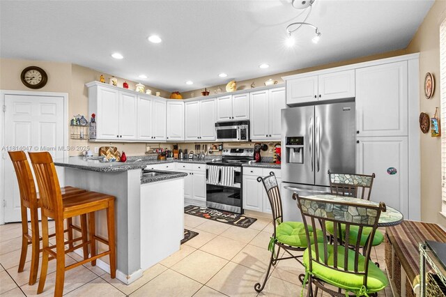 16316 SW 48th St, Miramar, FL 33027 - kitchen featuring stainless steel appliances, light tile patterned flooring, white cabinetry, a breakfast bar, and recessed lighting