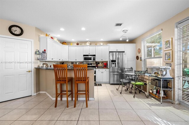 16316 SW 48th St, Miramar, FL 33027 - kitchen featuring stainless steel appliances, a peninsula, light tile patterned floors, white cabinetry, and recessed lighting