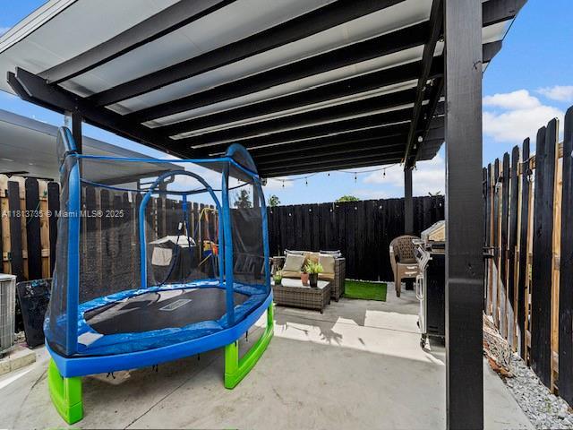 18058 SW 147th Ct, Miami, FL 33187 - fenced backyard with a trampoline and a patio area