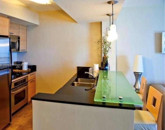 18683 Collins Ave Unit 2510, Sunny Isles Beach, FL 33160 - kitchen with appliances with stainless steel finishes, dark countertops, pendant lighting, a peninsula, and light tile patterned floors