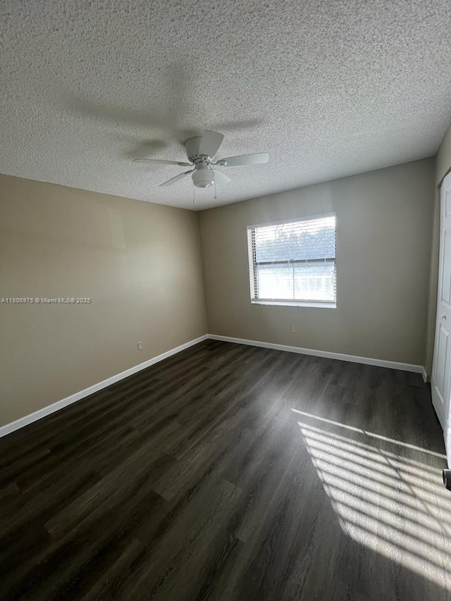 617 Ixoria Ave Unit 18, Fort Pierce, FL 34982 - spare room with dark wood-type flooring, ceiling fan, baseboards, and a textured ceiling