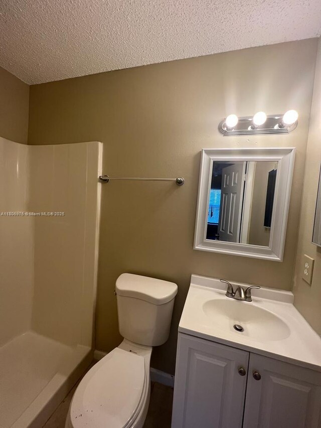 617 Ixoria Ave Unit 18, Fort Pierce, FL 34982 - bathroom featuring a textured ceiling, vanity, toilet, and a shower