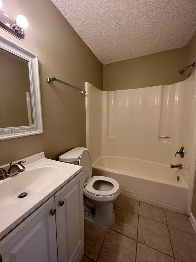 617 Ixoria Ave Unit 18, Fort Pierce, FL 34982 - full bathroom with a textured ceiling, tile patterned flooring, vanity, shower / tub combination, and toilet