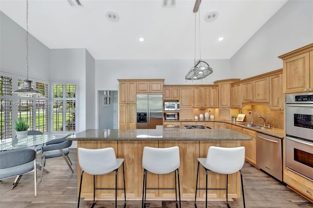 13241 SW 32nd Ct, Davie, FL 33330 - kitchen featuring stainless steel appliances, high vaulted ceiling, a center island, a sink, and backsplash