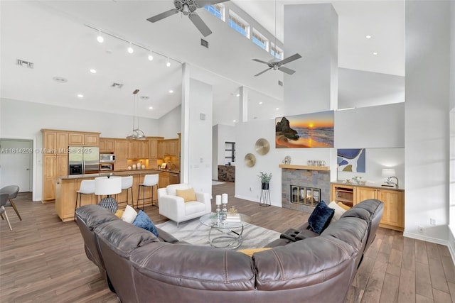 13241 SW 32nd Ct, Davie, FL 33330 - living room featuring a ceiling fan, high vaulted ceiling, light wood finished floors, a fireplace, and track lighting