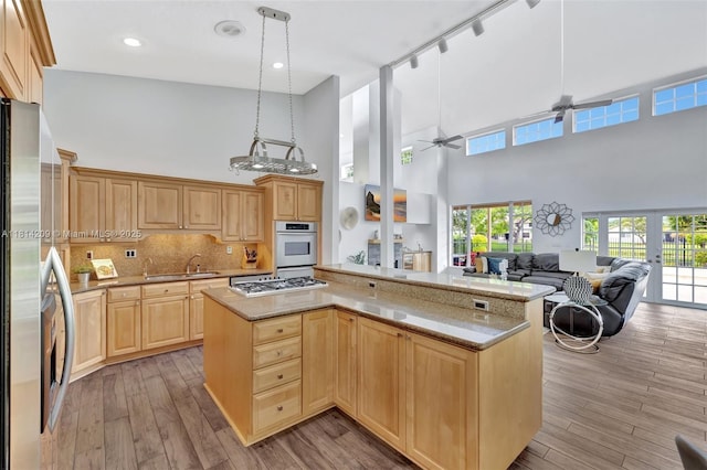 13241 SW 32nd Ct, Davie, FL 33330 - kitchen with stainless steel appliances, a high ceiling, light brown cabinets, ceiling fan, and light wood-type flooring