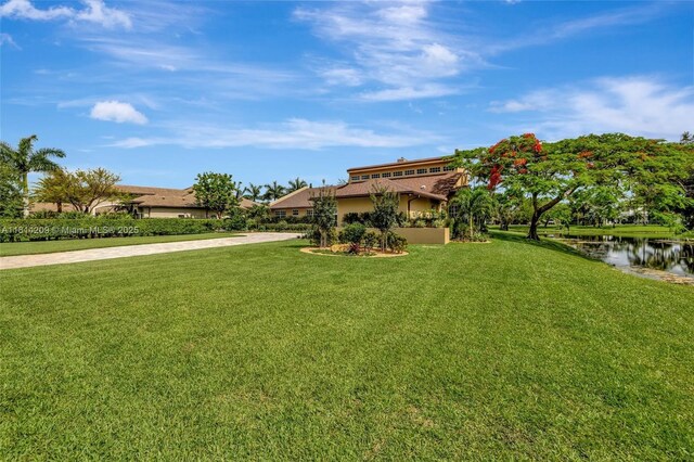 13241 SW 32nd Ct, Davie, FL 33330 - view of green lawn with driveway and a water view