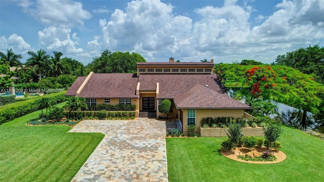 13241 SW 32nd Ct, Davie, FL 33330 - view of front of house with a front lawn, a chimney, stucco siding, and driveway