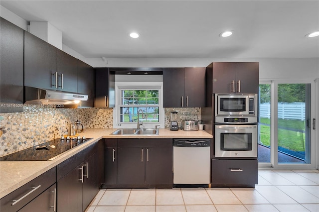 14630 SW 147th Ct, Miami, FL 33196 - kitchen with appliances with stainless steel finishes, under cabinet range hood, a sink, light countertops, and decorative backsplash