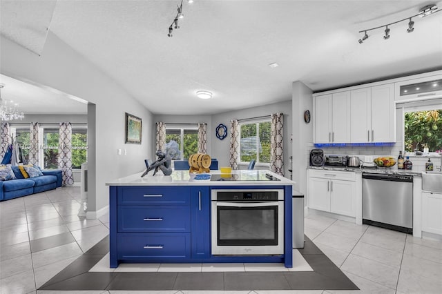 15240 SW 188th St, Miami, FL 33187 - kitchen featuring stainless steel appliances, rail lighting, white cabinets, light tile patterned floors, and a textured ceiling