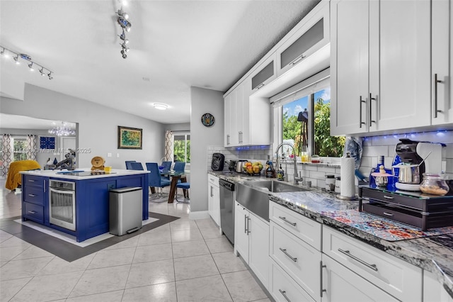 15240 SW 188th St, Miami, FL 33187 - kitchen featuring decorative backsplash, appliances with stainless steel finishes, white cabinets, blue cabinetry, and light tile patterned floors