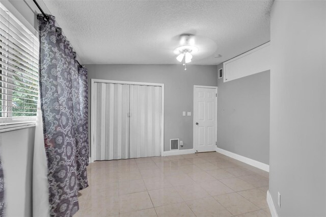 15240 SW 188th St, Miami, FL 33187 - unfurnished bedroom featuring a textured ceiling, light tile patterned flooring, and a closet
