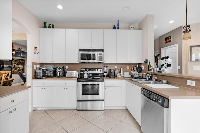 8753 SW 3rd Ln, Miami, FL 33174 - kitchen featuring stainless steel appliances, arched walkways, light countertops, light tile patterned flooring, and a peninsula