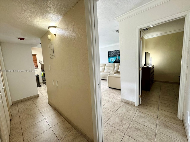 4050 NW 135th St Unit 15-11, Opa-Locka, FL 33054 - hall featuring a textured ceiling, crown molding, a textured wall, light tile patterned flooring, and baseboards
