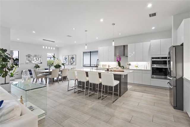 4381 SW 178th Ave, Miramar, FL 33029 - kitchen with appliances with stainless steel finishes, modern cabinets, a breakfast bar area, white cabinetry, and recessed lighting