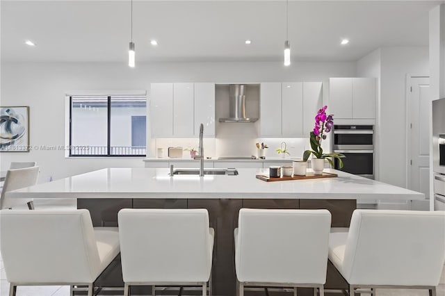 4381 SW 178th Ave, Miramar, FL 33029 - kitchen featuring wall chimney exhaust hood, a sink, white cabinetry, light countertops, and stainless steel double oven