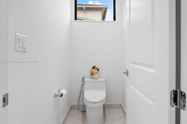 4381 SW 178th Ave, Miramar, FL 33029 - bathroom with marble look tiles, toilet, and baseboards