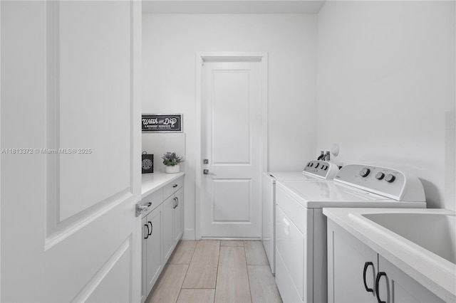4381 SW 178th Ave, Miramar, FL 33029 - laundry area featuring washing machine and clothes dryer, cabinet space, and light wood-style flooring