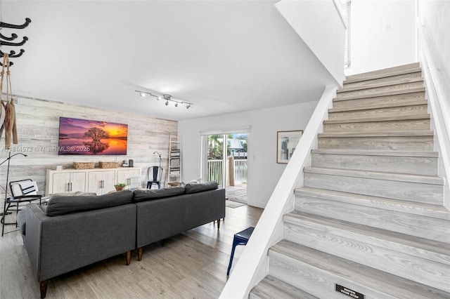 1370 NE 40th Dr, Oakland Park, FL 33334 - living area featuring wood walls, an accent wall, stairs, and wood finished floors